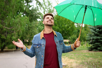 Man with umbrella outdoors on rainy day
