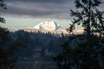 US, WA, Kitsap Peninsula. View from Bainbridge Island of Olympic Mountains and waterfront homes of Brownsville. These peaks known as 'the Brothers'.
