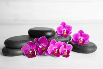 Fototapeta na wymiar Spa stones and orchid flowers on white wooden table