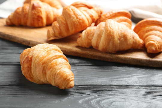 Fresh croissants on dark wooden table. French pastry
