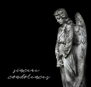 stone memorial grieving angel statue on black background. condolence, mourning cards or obituary. inscription "sincere condolences". soft focus