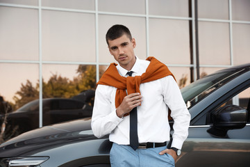 Attractive young man near luxury car outdoors