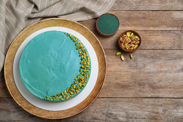 Flat lay composition with spirulina cheesecake on wooden table. Space for text