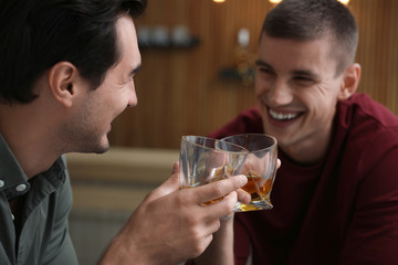 Young men drinking whiskey together in bar