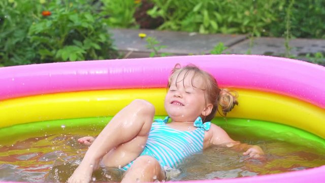 a child swims in an inflatable pool