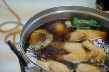 chicken boiling in fish sauce soup. boiled chicken