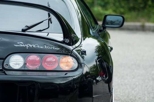  closeup of rear light  of black toyota supra parked in the street