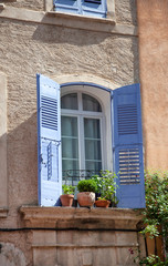 Fototapeta na wymiar House Facade With Wooden Shutters In Provence