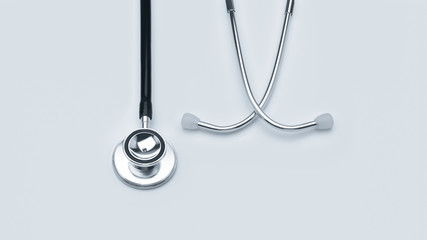 Stethoscope on white table background with copy space. Top view.