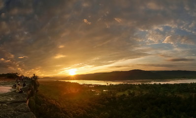 Mountain view morning above Mekong river around with the hills and yellow sun light in cloudy sky background, sunrise at Pha Taem View Point, Pha Taem National Park, Ubon Ratchathani, Thailand.