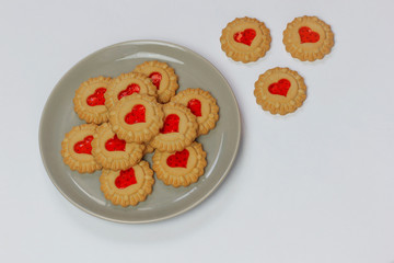 Valentines day heart shaped red jam filled cookies on plate isolated on white .top view.space for text and copy