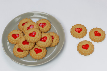 Valentines day heart shaped red jam filled cookies on plate isolated on white .top view.space for text and copy
