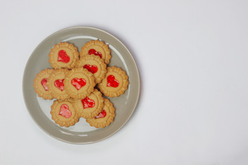 Valentines day heart shaped red jam filled cookies on plate isolated on white .top view.space for text and copy