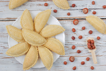 Traditional Azerbaijan holiday Novruz cookies baklava on white plate on the white background with nuts and shakarbura,tea,lemon,kata,mutaki,flat lay,top view,space for copy © Husniyya