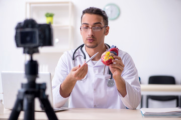 Young male doctor cardiologist recording video for his blog