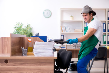 Young handsome contractor cleaning the office