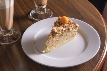 layer cake with cream on restaurant table, white plate