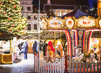 Traditional Christmas market in Europe. Carousel decorated with lights, Christmas fair concept.