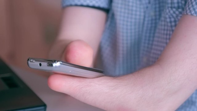 Disabled man with amputated stump hands dials number on mobile phone presses buttons. Problem of adaptation to usual life without wrists. Hands closeup. Independent Invalid person with disabilities.