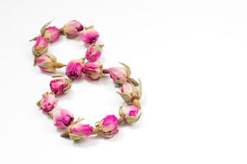 Obraz premium Greeting Card International Women's Day on March 8th. Dry pink roses in the form of number eight.
