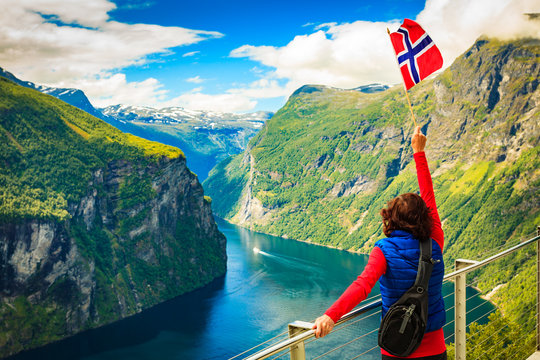 Tourist over Geirangerfjord with norwegian flag