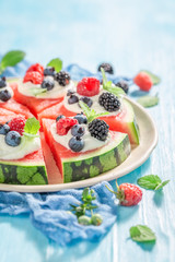 Closeup of watermelon pizza with berry fruits and cream