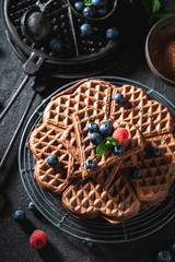 Delicious and tasty waffles made of cocoa with berries