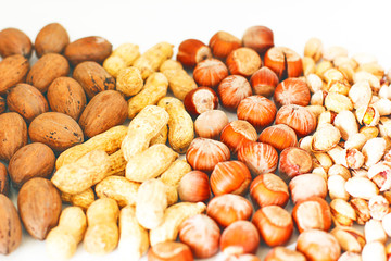 Various nuts selection: hazelnuts, pistachio and pecans in glass,space for copy or text,selective focus