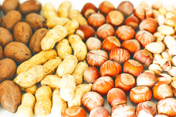 Various nuts selection: hazelnuts, pistachio and pecans in glass,space for copy or text,selective focus