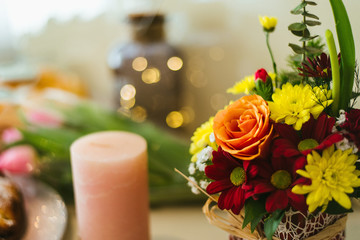bouquet of flowers and candle and fairy lights at the background 