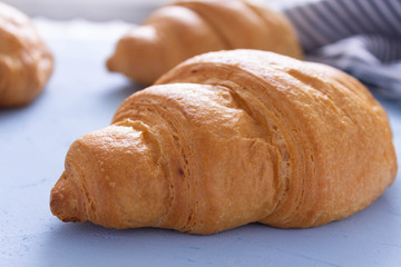 Tasty croissants on blue cement background.Side view.
