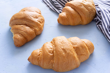 Tasty croissants on blue cement background.Top view.