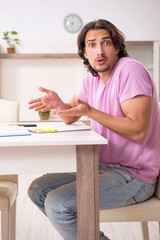 Young male student preparing for exams at home