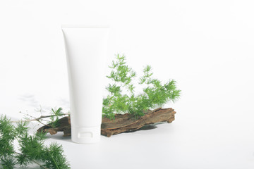 cosmetic lotion cream pakage tube with wood branch green natural leaf tree herbal with summer season, beauty spa treatment concept, top view