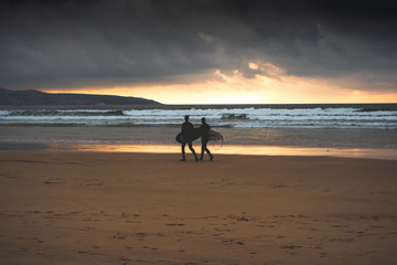 Fototapeta na wymiar silhouette of surfers on the beach