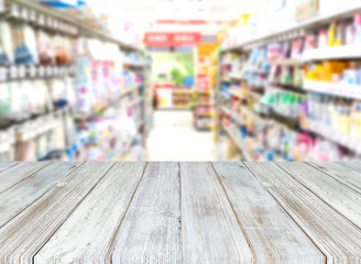 Perspective wood table on blurred abstract interior of super market department store that provides a surface for the storage or display of your products