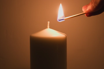 Lighting a candle with a burning match