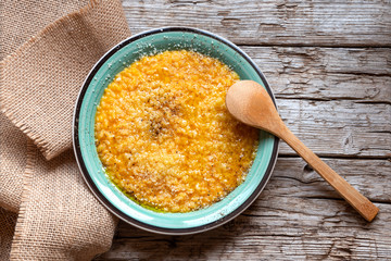 Pumpkin risotto with parmesan, black pepper and olive oil on old wooden background. Top view