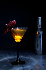 red cocktail with umbrella and olive