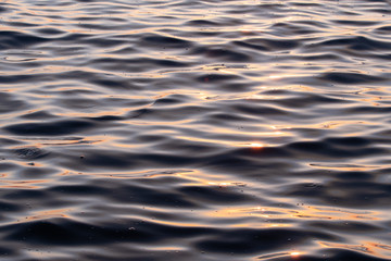 Close up picture of ocean waves at beach during sunset in Izmir in Turkey. Golden light on water.