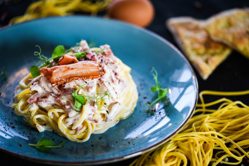fresh italian spaghetti carbonara with tasty ingredients - cream, egg, bacon