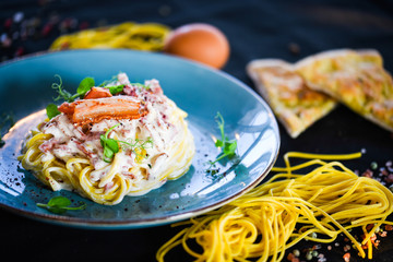 fresh italian spaghetti carbonara with tasty ingredients - cream, egg, bacon