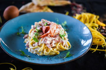 fresh italian spaghetti carbonara with tasty ingredients - cream, egg, bacon