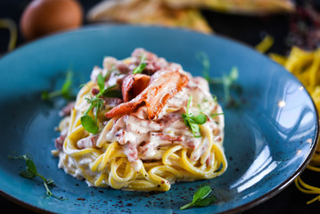 fresh italian spaghetti carbonara with tasty ingredients - cream, egg, bacon
