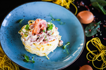 fresh italian spaghetti carbonara with tasty ingredients - cream, egg, bacon