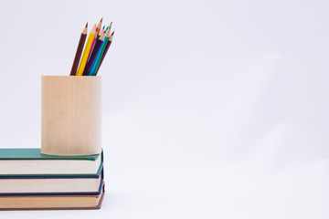 colored pencils in the beaker and books, concept back to school