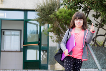 girl on the stairs of the school with backpack and folder