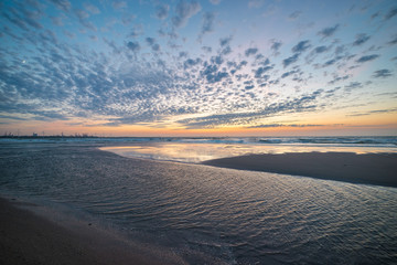 Colorful evening sky with beautiful sheep clouds over the sea at sunset