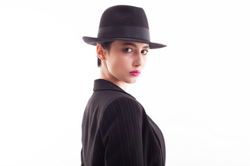 Attractive young female wearing a retro black hat in studio over white background