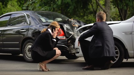 Female driver calling insurance company after road accident, rear-end collision